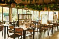 um restaurante com mesas e cadeiras em uma sala com janelas em San Ranieri Hotel em Pisa