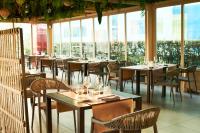 um restaurante com mesas, cadeiras e janelas em San Ranieri Hotel em Pisa