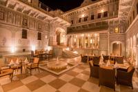 マンダワにあるThe Legacy Mandawaの建物の中にテーブルと椅子があるレストラン