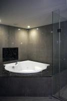 a bath tub in a bathroom with a glass shower at Talmud Hotel Kaohsiung LoveRiver in Kaohsiung