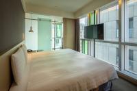 a bedroom with a large bed and a flat screen tv at Chaiin Hotel - Dongmen in Taipei