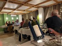 Un hombre de pie en una mesa con una botella de vino. en Finca Elements, en Comares