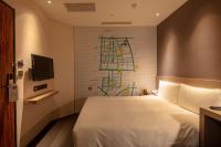 a hotel room with a bed and a painting on the wall at Chaiin Hotel - Dongmen in Taipei