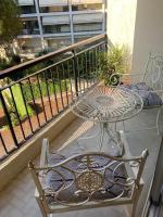 a table and chair on a balcony with a table at Cosy Studio Cannes Center beaches shopping and congresses LIVE IN MERLE in Cannes