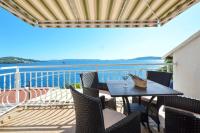 a table on a balcony with a view of the water at Apartment in Seget Vranjica with sea view, balcony, air conditioning, WiFi 91-2 in Seget Vranjica