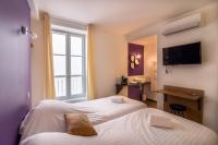 a hotel room with two beds and a window at Sarlatitude, Studios &amp; Chambres in Sarlat-la-Canéda