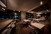 um restaurante com mesas, cadeiras de madeira e luzes em The Royal Park Canvas Ginza Corridor em Tóquio