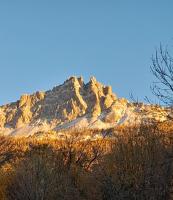 a snow covered mountain with trees in front of it at Le Piolit in Prunières