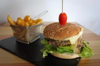 een hamburger met tomaat erop en een portie friet bij Sun Sea camping le Bosc in Saint-Cyprien