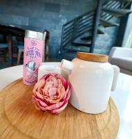 a pink rose sitting next to a tea pot and a candle at H Hotel El Nido - Vegan Friendly Hotel Managed by H Hospitality Group in El Nido