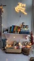 uma prateleira com livros, uma cesta de pão e luzes em Elis Homestay AC room with Breakfast em Mahabalipuram
