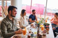 a group of people sitting around a table eating food at Zoku Copenhagen in Copenhagen
