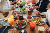 a group of people sitting around a table eating food at Zoku Copenhagen in Copenhagen