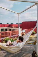a man and a woman sitting in a hammock at Zoku Copenhagen in Copenhagen