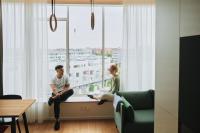 a man and a woman sitting on a window sill at Zoku Copenhagen in Copenhagen