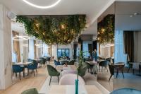 Un restaurante con mesas y sillas y una gran lámpara de araña. en Hotel Clipa, en Drobeta-Turnu Severin