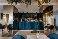 Un restaurante con sillas y mesas azules y un bar. en Hotel Clipa, en Drobeta-Turnu Severin
