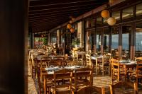 Un restaurante con mesas y sillas en una terraza. en Althaia Hotel, en Thermo