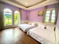 two beds in a room with purple walls and windows at 伊莎愛莉溜滑梯親子民宿 in Wujie