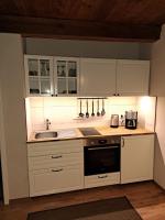 a kitchen with white cabinets and a sink at Pension Müllers Mühle in Großenhain