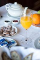a table with a glass of orange juice and cookies at Hotel Rural Monte da Provença in Elvas