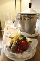 a plate of fruit on a table with wine glasses at Weinkastell Zum Weissen Ross in Kallstadt