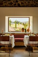 Un comedor con dos mesas y una ventana. en La Dehesa de Don Pedro, en Monesterio