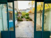 an open door of a building with a walkway at Le Jardin Des Sacres - HyperCentre Cathédrale in Reims