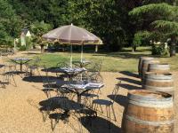 Un grupo de mesas y sillas con una sombrilla. en Château De La Coutancière, en Brain-sur-Allonnes