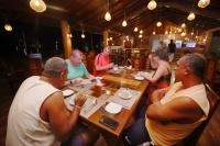 um grupo de pessoas sentadas ao redor de uma mesa em um restaurante em Horizon KiteSurfing Beach Resort em Kalpitiya