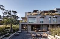 a house with a courtyard and benches at Casagrande Hotel & Beach Club in José Ignacio