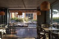 a restaurant with tables and chairs and windows at Casagrande Hotel & Beach Club in José Ignacio
