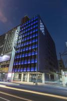 un edificio alto con ventanas azules en una calle de la ciudad en The Cloud Hotel, en Taichung