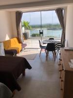 a bedroom with a bed and a view of the water at Suítes Luxo Marambaia- Epic House in Rio de Janeiro