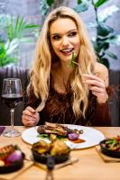 科沃布热格FACTORY RESORT wellness & spa的一位女士坐在桌边，面前摆着一盘食物