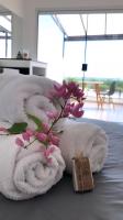 a towel with a flower on top of a bed at Suítes Luxo Marambaia- Epic House in Rio de Janeiro