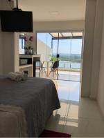 a bedroom with a bed and a view of the ocean at Suítes Luxo Marambaia- Epic House in Rio de Janeiro