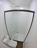 a bathroom with a toilet and a large mirror at Suítes Luxo Marambaia- Epic House in Rio de Janeiro