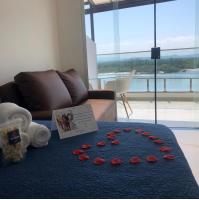 a room with a blue table with red roses on it at Suítes Luxo Marambaia- Epic House in Rio de Janeiro