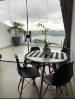 a dining room with a table and chairs and a large window at Suítes Luxo Marambaia- Epic House in Rio de Janeiro