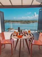 a table and chairs with a view of the water at Suítes Luxo Marambaia- Epic House in Rio de Janeiro