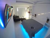 a room with a bed and a tv and a couch at Suítes Luxo Marambaia- Epic House in Rio de Janeiro