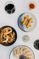 een tafel met borden en een glas wijn bij Hôtel & Appartements Monsigny in Nice