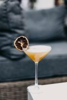 een drankje in een martiniglas met een schijfje sinaasappel bij Hôtel & Appartements Monsigny in Nice