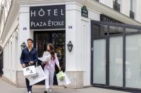a man and woman walking down a street with shopping bags at Hôtel Plaza Étoile in Paris