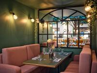 パリにあるロイヤル マドレーヌ ホテル＆スパの窓のあるレストラン(テーブル、椅子付)