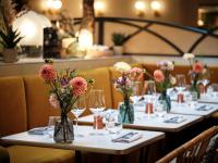 パリにあるロイヤル マドレーヌ ホテル＆スパのグラスと花瓶が置かれたテーブルの列