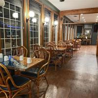 een restaurant met houten tafels en stoelen en ramen bij The Grand Tappattoo Resort, an Ascend Collection Resort in Otter Lake