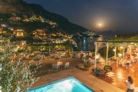 a view of a town at night with a swimming pool at Hotel Poseidon in Positano