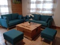 ein Wohnzimmer mit blauen Sofas und einem Couchtisch in der Unterkunft Chalet les Alpes - Le Sapey in Vénosc
